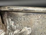 a silver cup with a bird on it in someone ' s hand