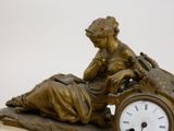 a statue of a woman with a clock on a table