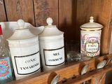 a wooden shelf with jars and glasses on it