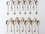 six silver spoons and two silver spoons on a white surface