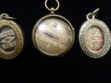 four antique pocket watches are displayed on a black surface