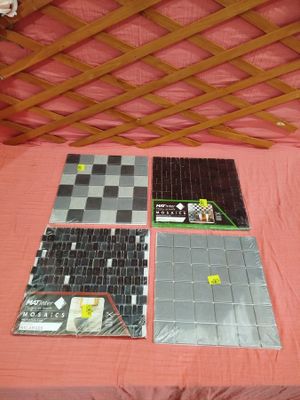 quatre carreaux de faïence posés sur un lit recouvert d'une couverture rose