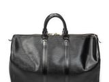 un sac de voyage noir posé sur une surface blanche