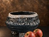 two apples that are sitting on a table next to a bowl