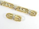 two pieces of gold and silver metal on a white surface