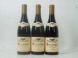 trois bouteilles de vin posées sur une table blanche