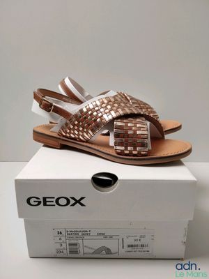 a close up of a box with a pair of sandals on it