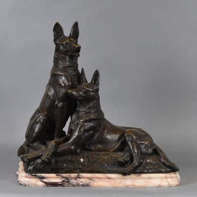 a bronze statue of two dogs and a cat on a marble base