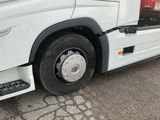 un camion blanc avec un pneu crevé, garé sur un parking