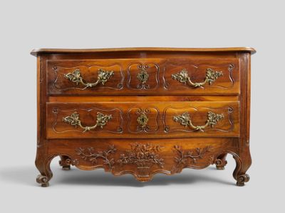 an antique chest of drawers with ornate carvings and brass handles