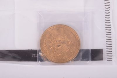 a gold coin in a plastic bag on a white surface