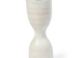 a white vase with a black top sitting on a white surface