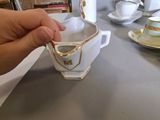a person holding a cup and saucer on a table