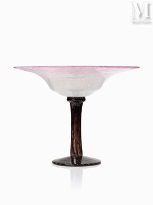 un bol en verre rose et blanc posé sur un socle en bois, lui-même posé sur une surface blanche