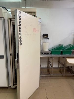 un grand réfrigérateur blanc dans une pièce dotée de nombreux plans de travail
