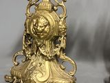 pair of antique brass candlesticks with ornate designs on each side