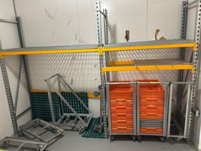 une pièce dans laquelle se trouve un rayonnage sur lequel sont posés des bacs orange