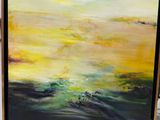 une peinture à l'huile représentant un coucher de soleil sur l'océan, posée sur une table