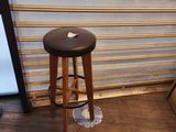 a black stool sitting in front of a window