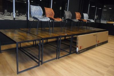 plusieurs chaises et tables dans une pièce aux murs noirs et au parquet