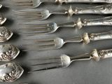 a lot of silver spoons and forks on a table
