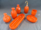 de nombreux vases orange et un porte-savon sur la table