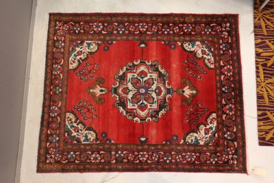 Tapis en laine à fond rouge et décor de fleurs géométriques …