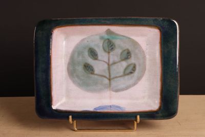 une assiette bleue et verte ornée d'un motif de feuilles