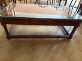 a glass table with a drawer underneath it on the floor