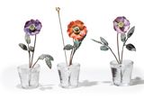 three glass vases with flowers in them sitting next to each other