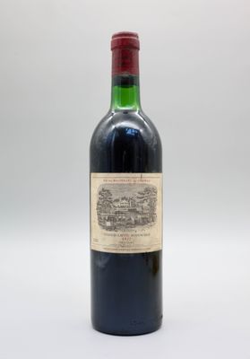 une vieille bouteille de vin posée sur une table blanche