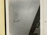 an old photo of a plane flying over a body of water