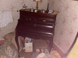 a messy room with a bed, dresser, lamp, and other items