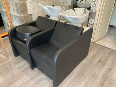 une chaise noire et un lavabo blanc dans une pièce