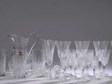 beaucoup de verres à vin et un pichet posés sur une table