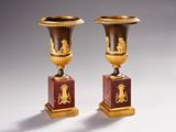 pair of antique vases with gold and red designs on marble bases