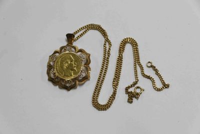 Gros plan sur un collier en or sur lequel se trouve une pièce de monnaie