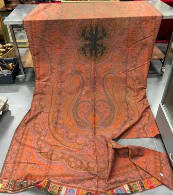 une écharpe à motif paisley orange et noir exposée dans un magasin