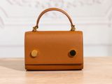 un petit sac à main marron posé sur une table en bois