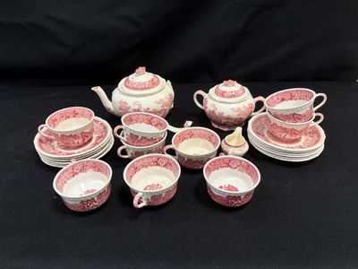 un assortiment d'assiettes et de tasses roses et blanches posées sur un fond noir