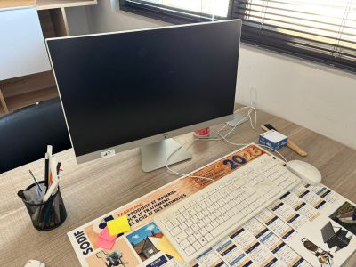 un écran d'ordinateur et un clavier posés sur un bureau dans un bureau à domicile