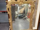 un miroir posé par terre devant une étagère