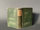 a green book with a brown label sitting on a table