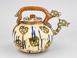 a blue and white tea pot with a wooden handle