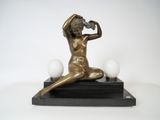 statue en bronze représentant une femme assise sur un socle en marbre surmonté de trois œufs