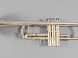 a silver trumpet sitting on top of a white table