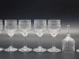 plusieurs verres à vin vides et une bouteille de vin posés sur une table