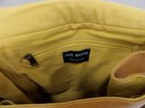 the inside of a yellow purse with a black label on it
