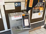 an atm machine with a hat on top of it