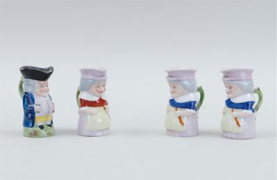 three miniature figurines of a man and a woman with hats and scarfs